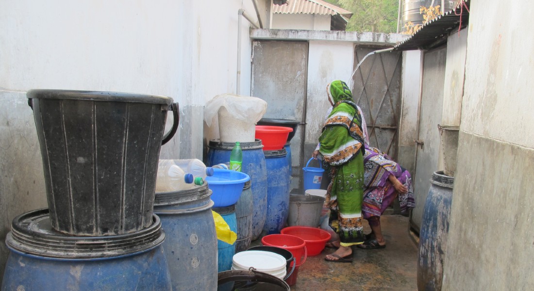 Woman collects water from buckets